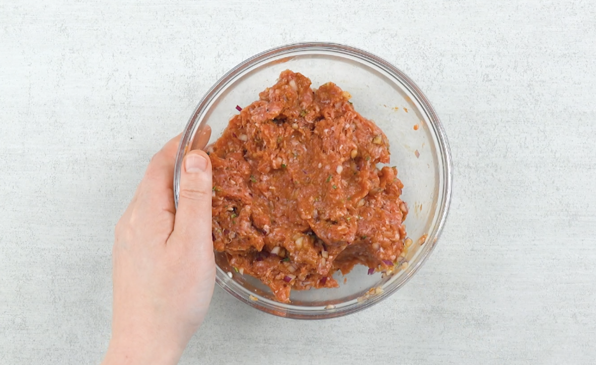 Hackfleisch mit GewÃ¼rzen und klein gehackten Zwiebeln in GlasschÃ¼ssel