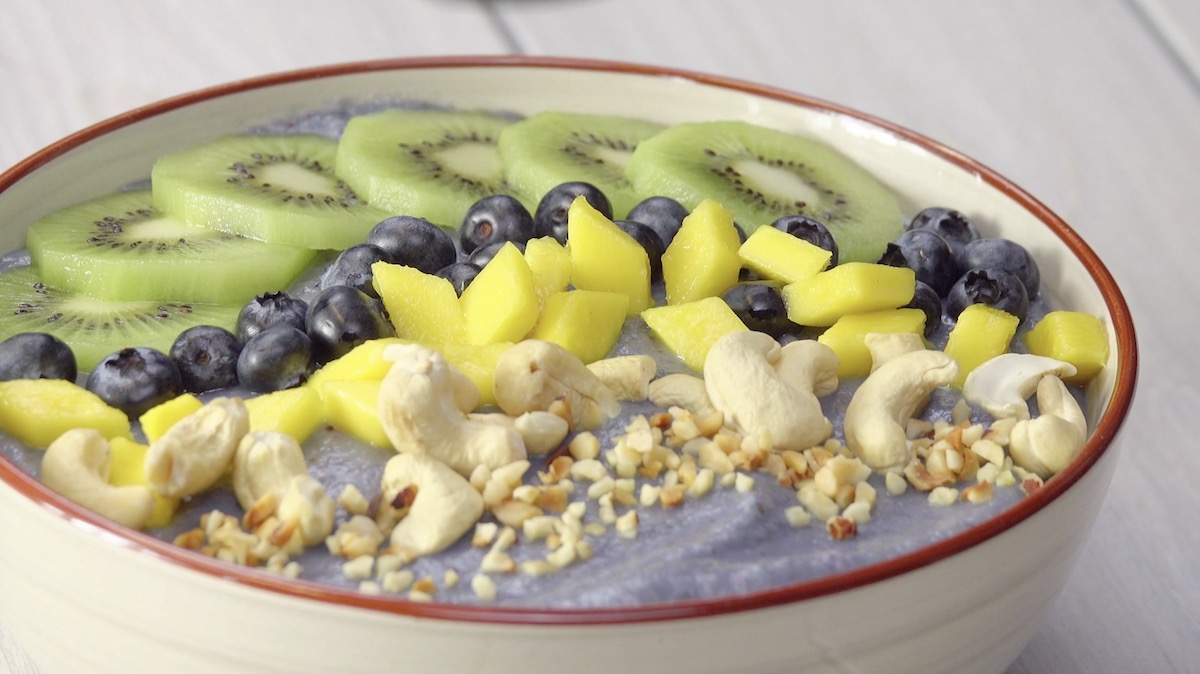 Smoothie-Bowl mit Kiwis, Blaubeeren, MangostÃ¼cken und Cashew- und HaselnÃ¼ssen