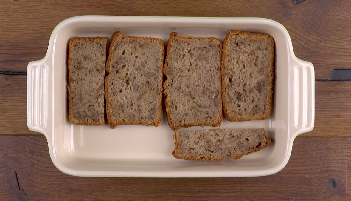 In Scheiben geschnittenes Bananenbrot wird als Boden in Auflaufform gelegt