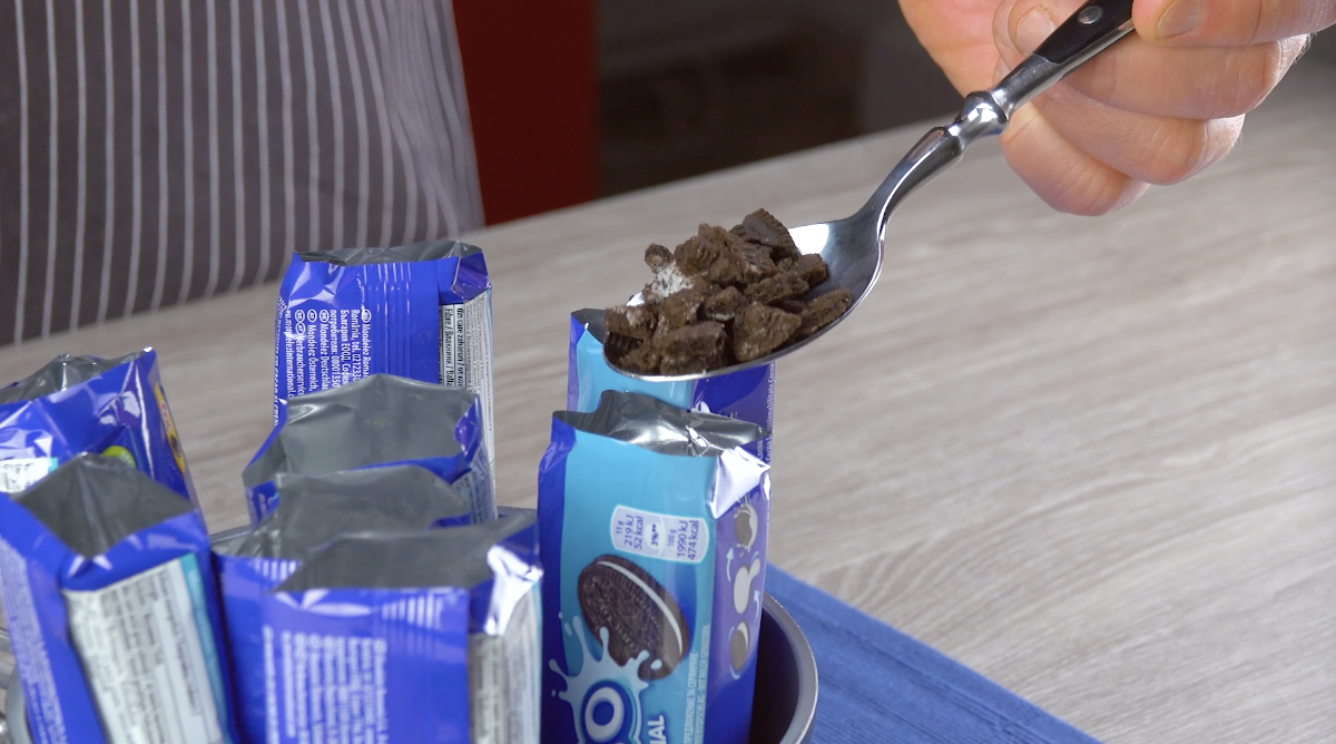 ZerbrÃ¶selte Oreokekse werden mit einem LÃ¶ffel in die Oreo-Verpackungen gefÃ¼llt