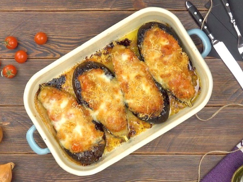 Aubergine al forno mit Mozzarella, 4 Auberginen in der Auflaufform, mit Käse überbacken, Draufsicht.