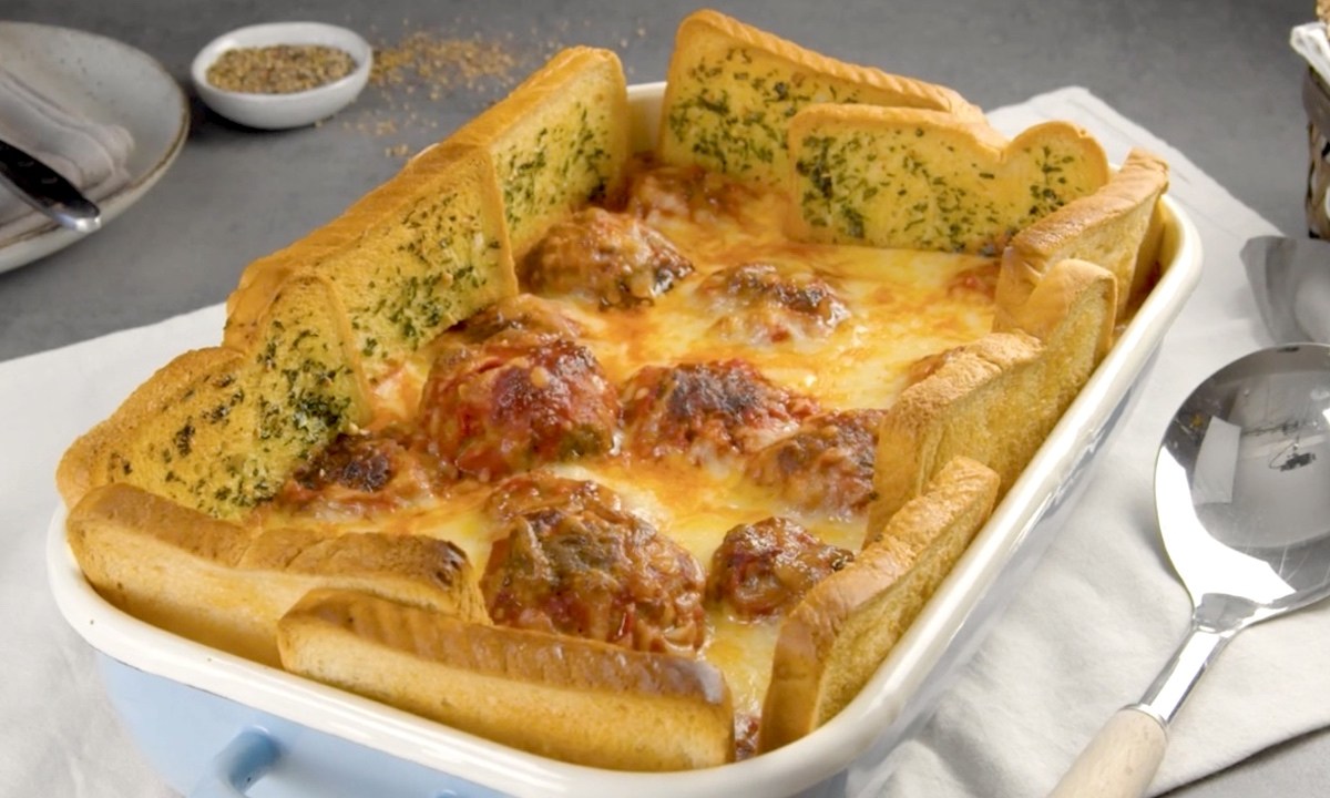 Köstlicher Hackbällchen-Auflauf mit Kräuterbutter-Toast-Zaun in der Auflaufform.