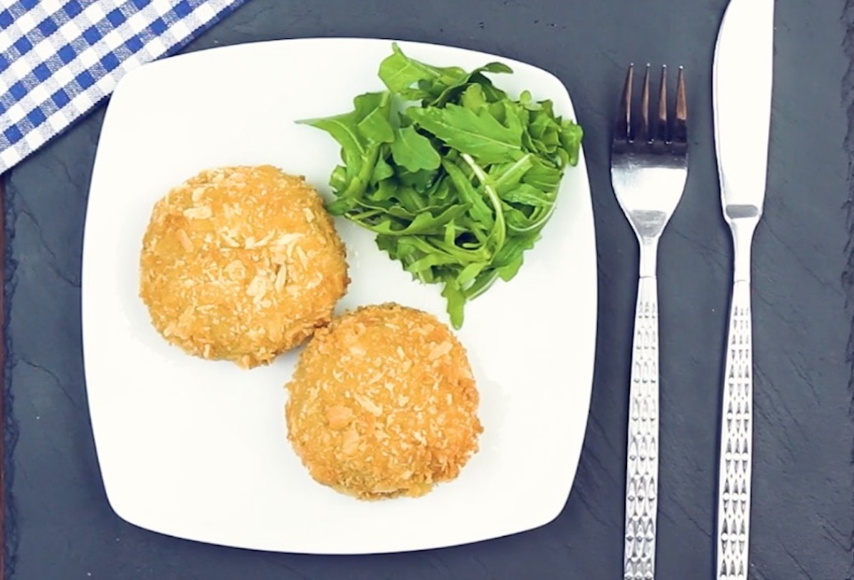 2 Cheeseburger-Zwiebelringe neben Rucola-Salat