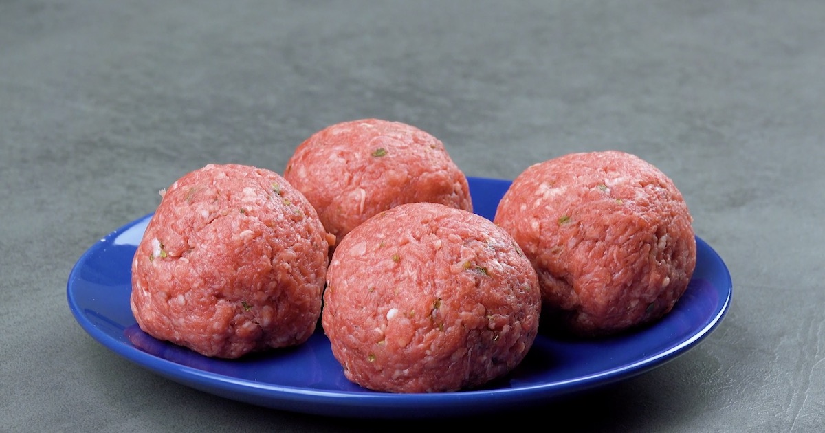 Das Hackfleisch wird zu vier mit KÃ¤se gefÃ¼llten BÃ¤llchen geformt. 