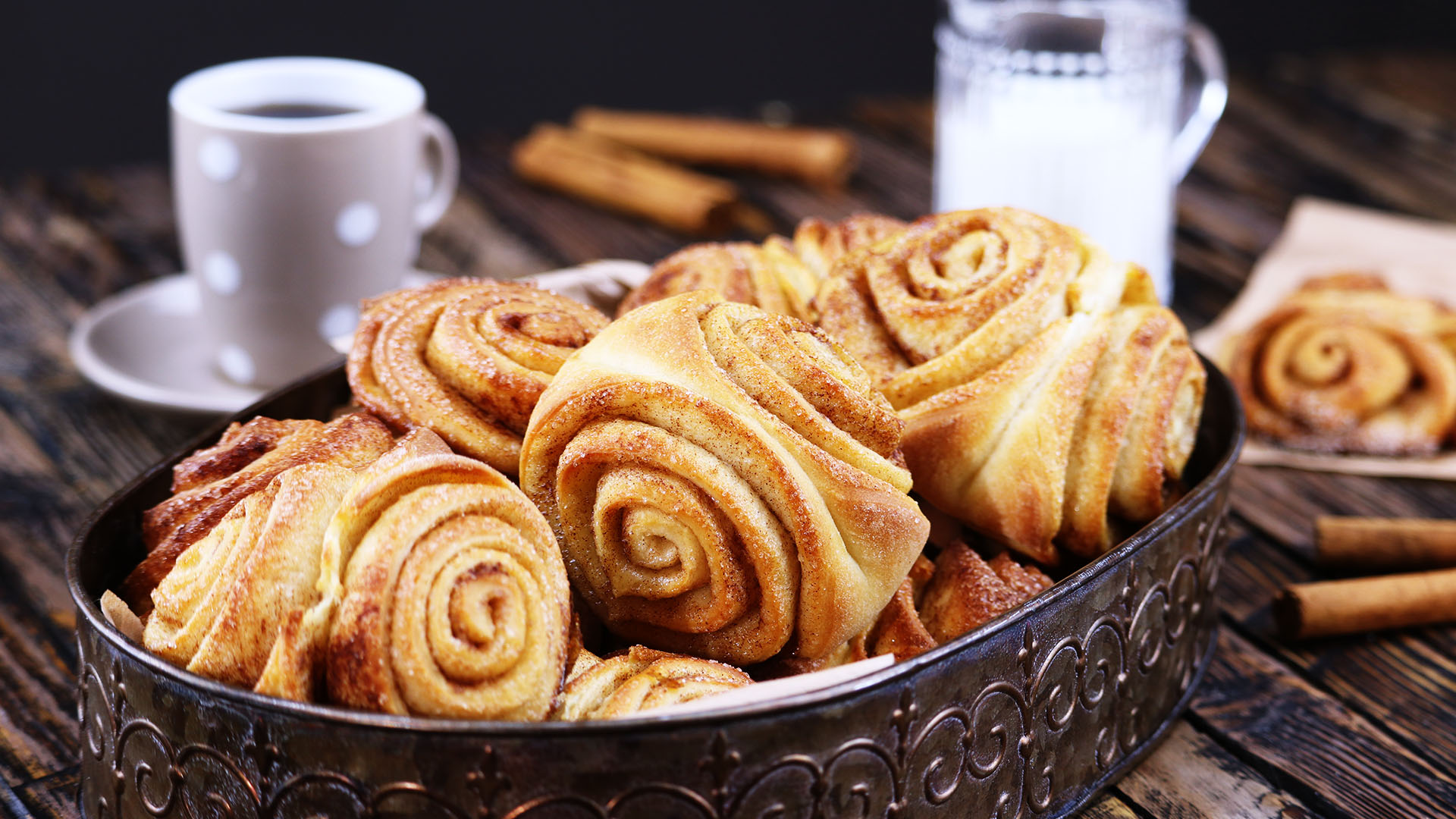 Franzbrötchen im Brotkorb und eine Tasse Kaffee im Hintergrund. 