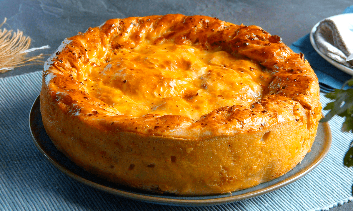 Empanada-Kuchen-mit-Haehnchenbrust-und-Pizzateig auf einer Kuchenform.