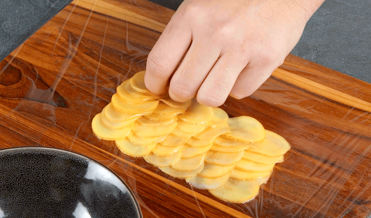 Kartoffelscheiben auf einer Lage Frischhaltefolie