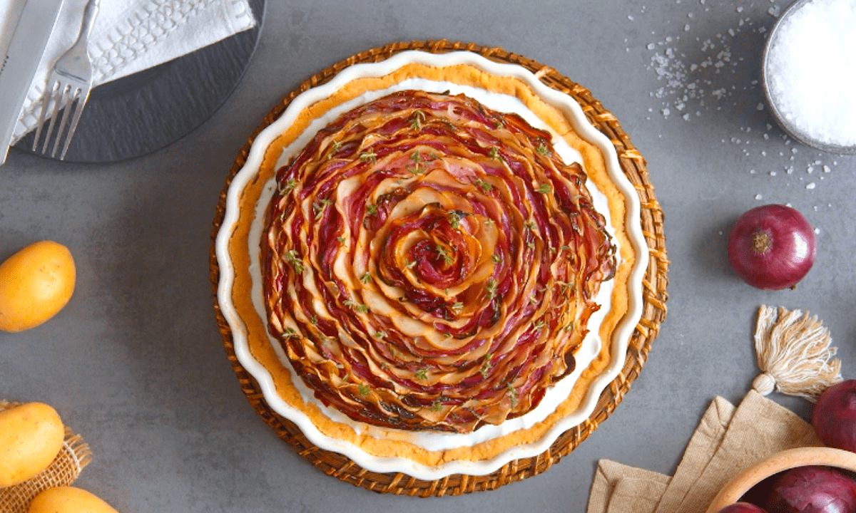 Zwiebelkuchen mit Mürbeteig, serviert in einer Tarteform.