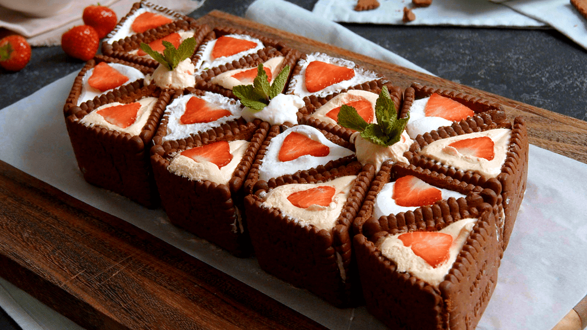 No-bake-Kuchen-mit-Butterkeksen, angerichtet auf einem Backpapier und Brett.