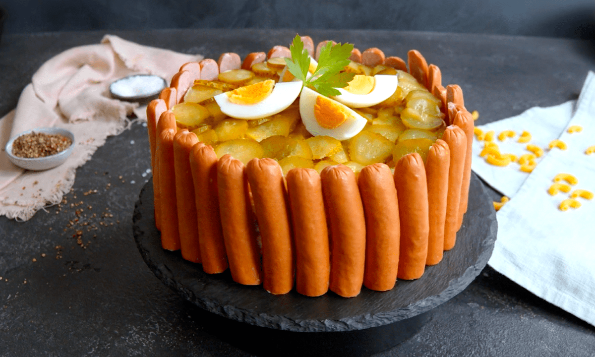 Nudelsalat als herzhafte Torte, angerichtet auf einem Teller.