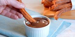 Süßkartoffel-Churros werden in Schokosoße gedippt.