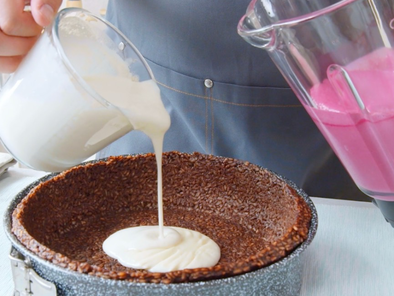 Zebrakuchen aus Milchreis: die Cremes in Weiß und Rosa werden auf den Kuchenteig gegossen.