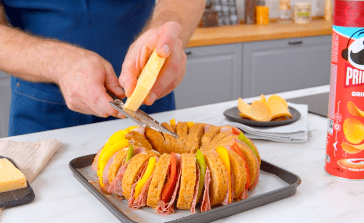 KÃ¤se wird Ã¼ber ein gefÃ¼lltes Brot gerieben