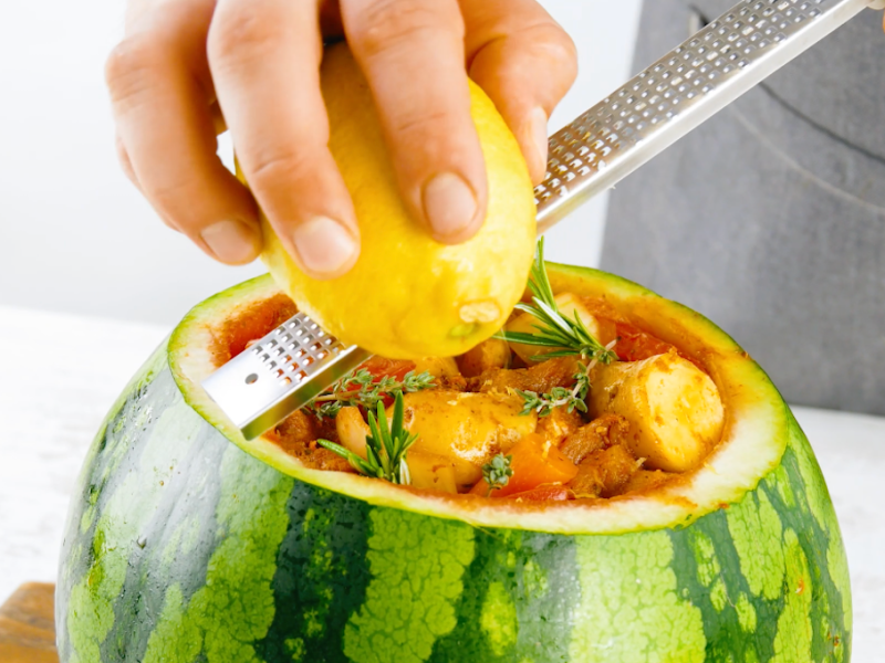Fleischtopf in Wassermelone, über den Zitronenschale gerieben wird.
