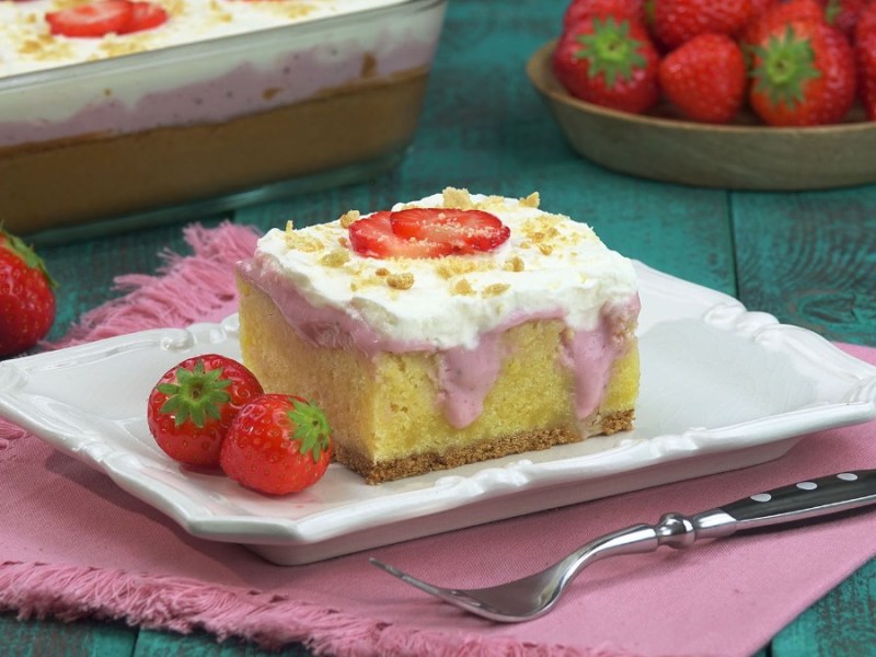 Ein Stück Erdbeer-Poke-Cake auf einem Teller.