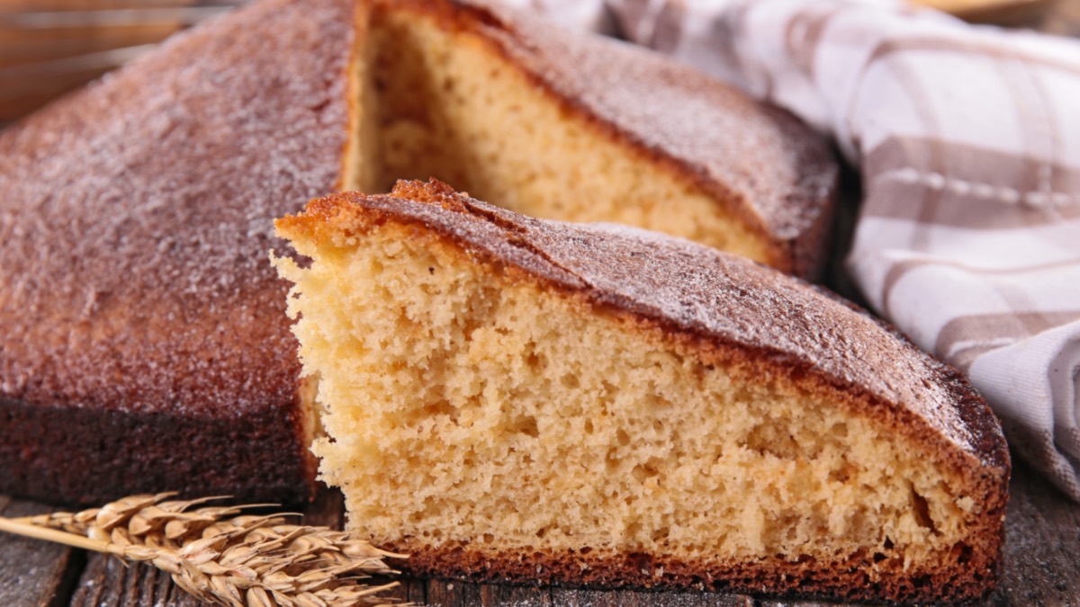 Ein Stück Joghurtkuchen liegt vor dem restlichen Kuchen.