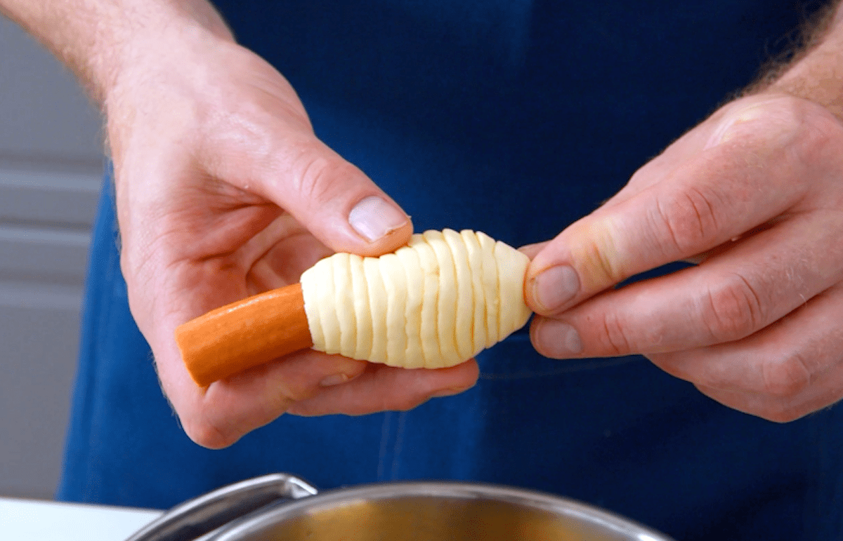 Ein WÃ¼rstchen wird mit Streifen aus BlÃ¤tterteig umwickelt