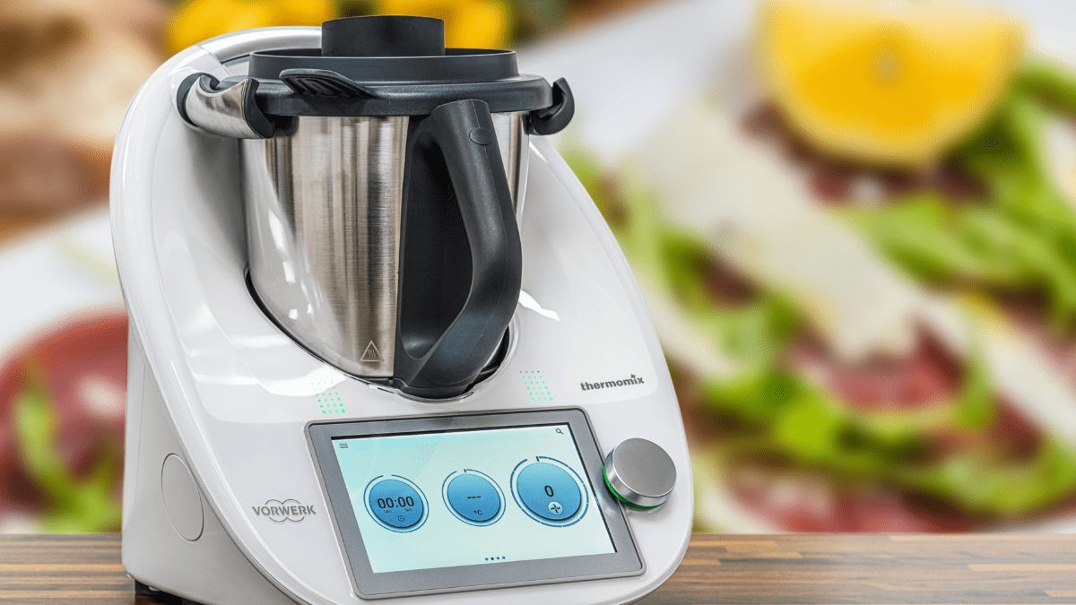 Ein Thermomix, im Hintergrund Lebensmittel