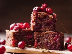 Gewürz-Brownies mit Glühwein-Kirschen gestapelt auf einem Brett.