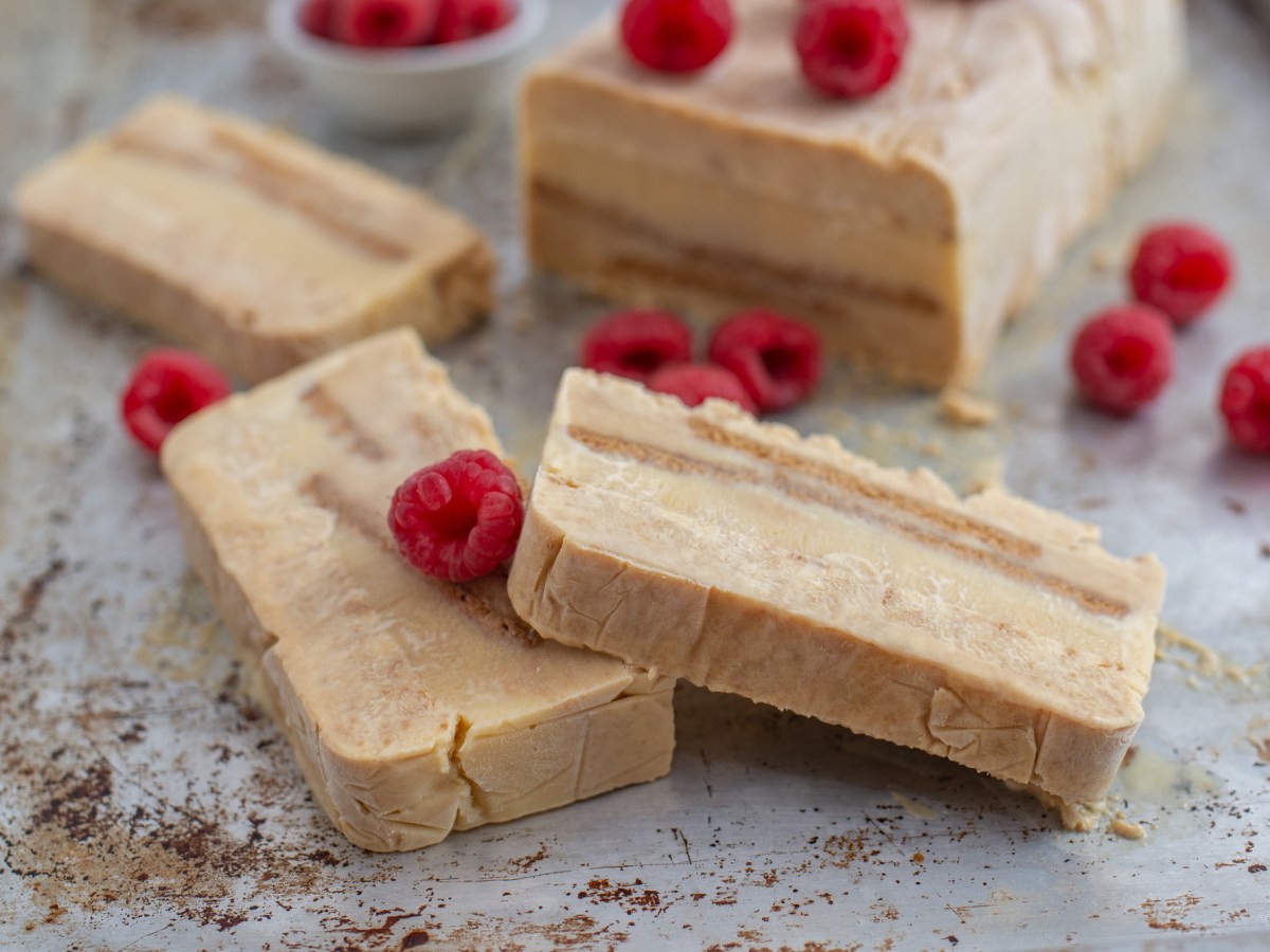 Marzipan-Spekulatius-Parfait auf einem grauen Untergrund mit Himbeeren garniert