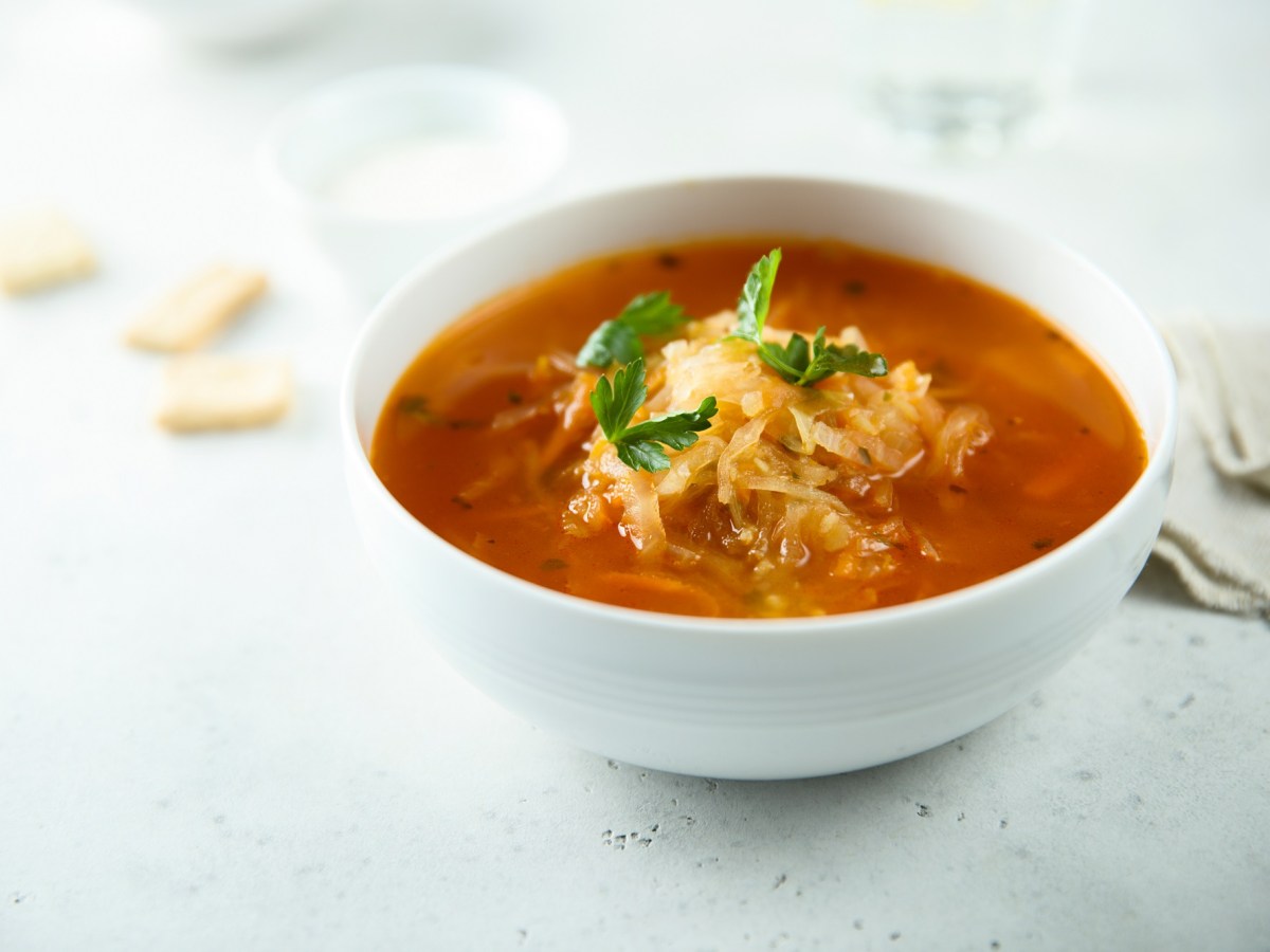 Eine SchÃ¼ssel Sauerkrautsuppe mit Petersilie garniert.