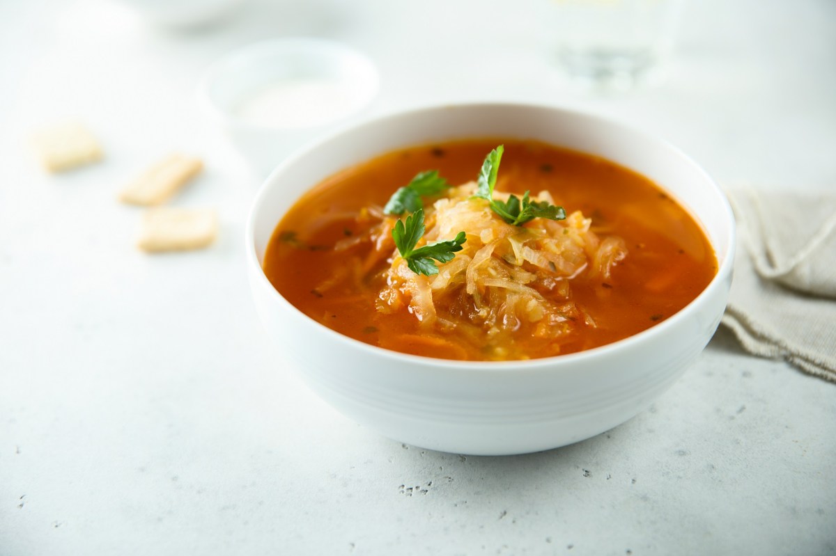 Eine SchÃ¼ssel Sauerkrautsuppe mit Petersilie garniert.