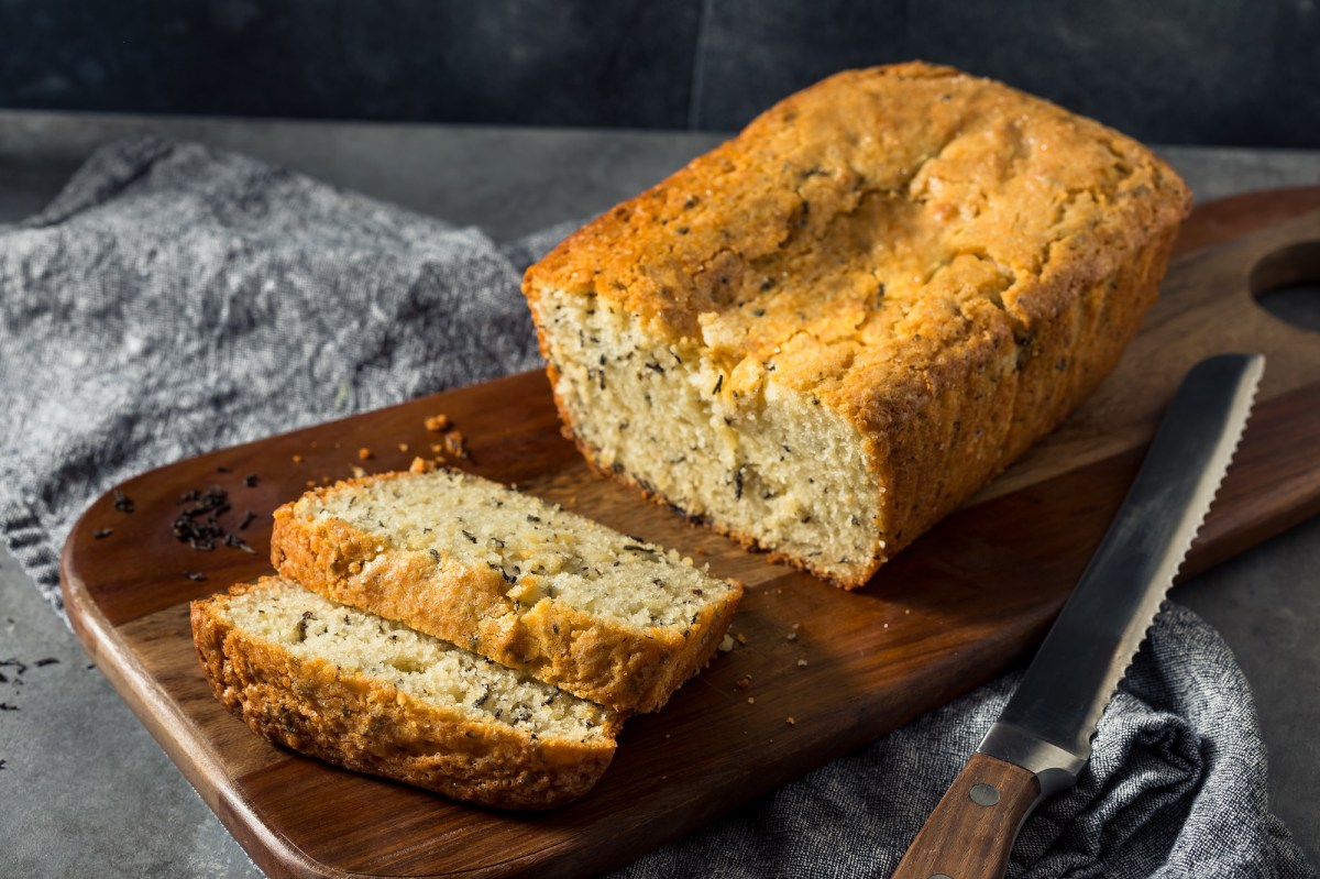 Holzbrett mit einem Earl grey Kastenkuchen und zwei abgeschnittenen Scheiben Kuchen.