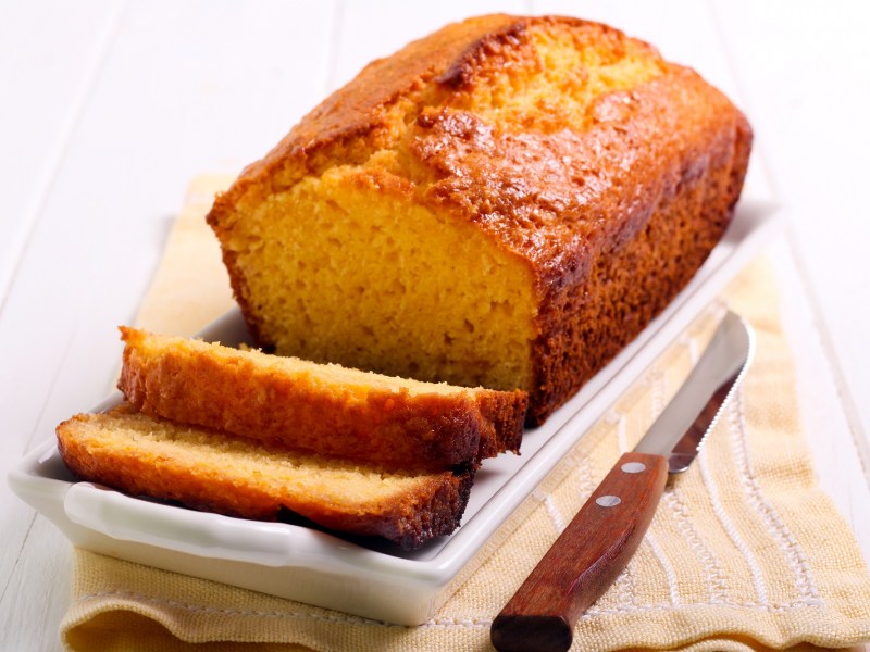 Angeschnittener Polenta-Kuchen mit Grapefruit auf einem weißen Servierteller