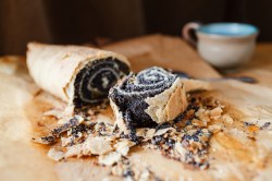 Ein angeschnittener Mohnstrudel auf Backpapier