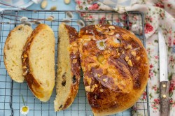 Kuchenrost mit angeschnittenem Osterbrot mit Mandeln und Rosinen.