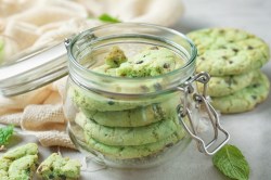 Schoko-Minz-Cookies in einem Einweckglas. Mehre Kekse liegen daneben.