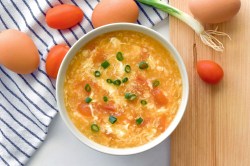 Eine Egg-Drop-Suppe mit Frühlingszwiebeln garniert.