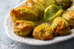 Gefüllte Zucchini-Blüten auf einem großen Teller.