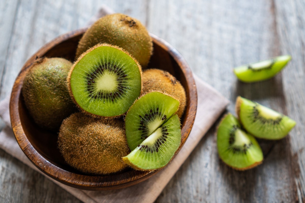 Kiwi mit Schale essen: eine brauen Schüssel mit halbierten Kiwis mit Schale, daneben Kiwiviertel.