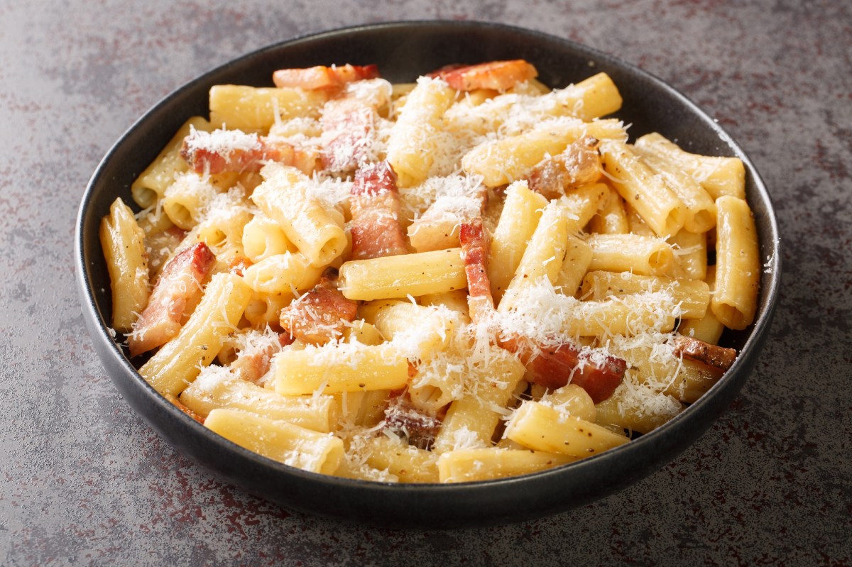 Ein Teller mit Pasta alla gricia auf dunklem Untergrund.