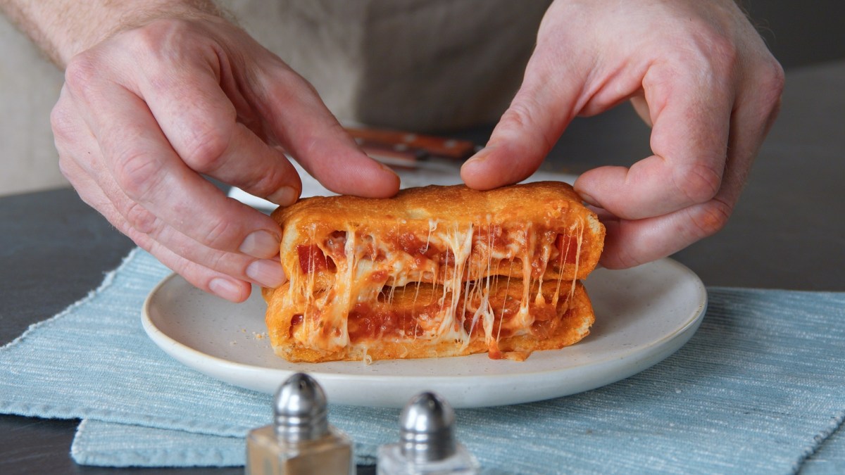 Pizzatoast-Taschen auf einem Teller, gefüllt mit Käse und Tomatensoße.