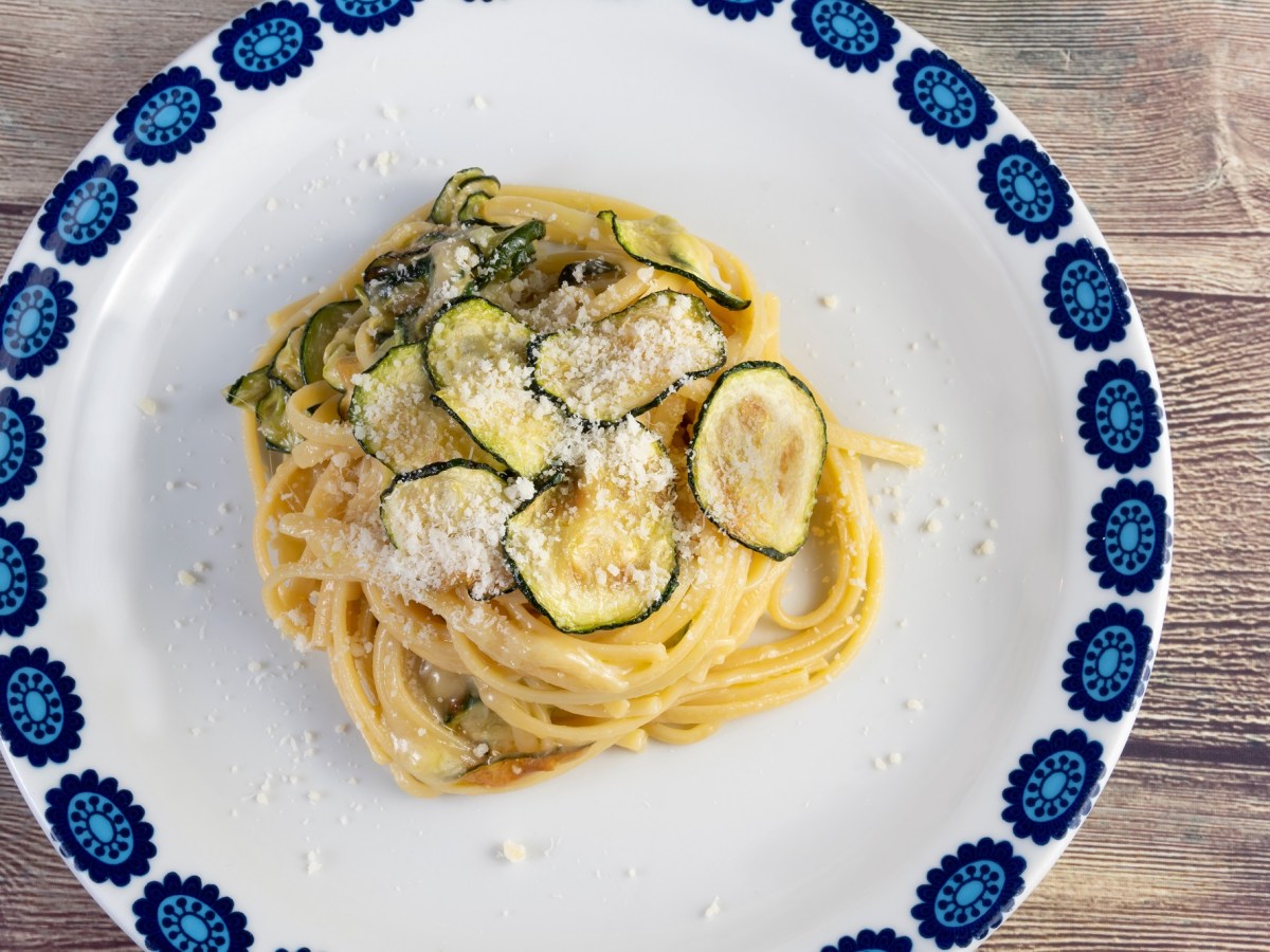 Teller mit blauem Rand und einer Protion Spaghetti alla nerano.