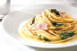 Weißer Teller mit einer Portion Spinat Carbonara