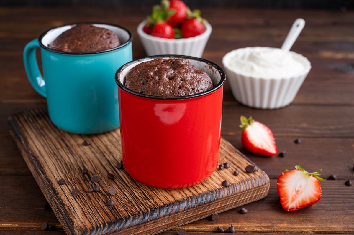 Zwei Tassen-Brownie auf einem Tisch, dekoriert mit Erdbeeren.