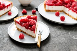 Ein Stück Zitronen-Himbeer-Käsekuchen auf einem Teller.