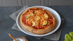 Teller mit Pizza aus Vollkorn-Pizzateig