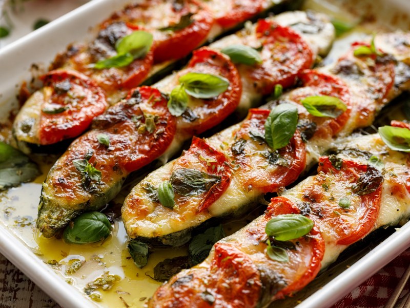 Gefüllte Zucchini mit Mozzarella und Tomaten in einer Auflaufform.