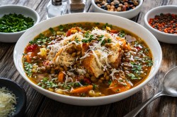 Ein Teller Linsensuppe mit Parmesan und Croûtons.