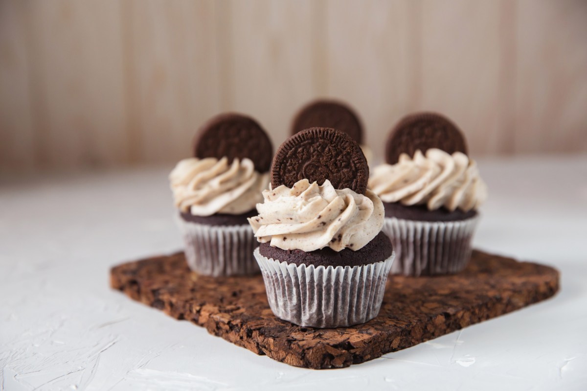 Oreo-Cupcakes mit einem Keks verziert auf einem Brett.