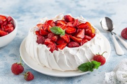 Eine Pavlova mit Erdbeeren auf einem Tisch.