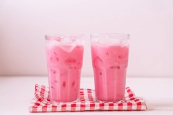 Zwei Gläser Pink Drink auf rot-weißem Tischtuch.