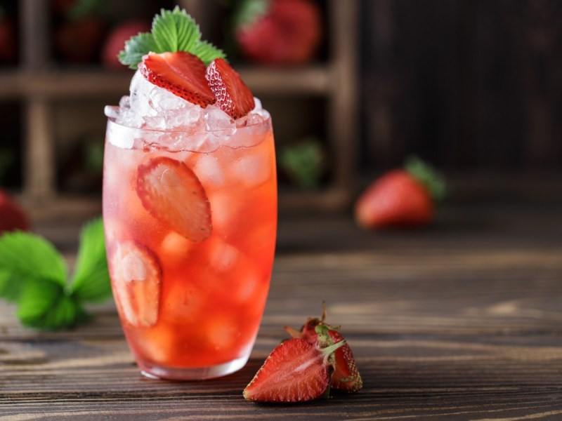 Ein Glas Strawberry Colada mit frischen Erdbeeren.