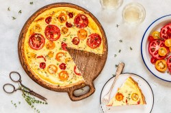 Eine angeschnittene Tomaten-Ricotta-Quiche in der Draufsicht.