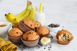 Mehrere Bananen-Muffins auf einem Kuchengitter, Bananen daneben