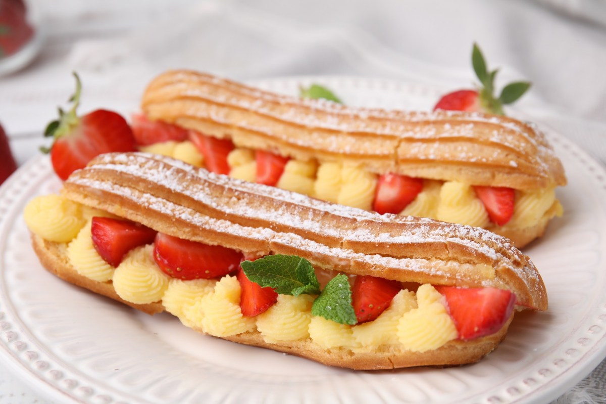 Zwei Erdbeer-Eclairs auf einem Teller.